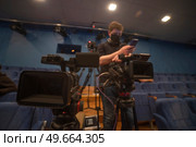 masked cameraman is filming a television show in the studio. TV. Стоковое фото, агентство Ingram Publishing / Фотобанк Лори