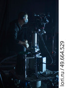 masked cameraman is filming a television show in the studio. TV. Стоковое фото, агентство Ingram Publishing / Фотобанк Лори