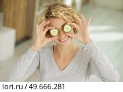 playful young woman standing covering her eyes with cucumber. Стоковое фото, агентство Ingram Publishing / Фотобанк Лори