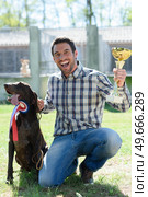 man holding trophy with his dog on the side. Стоковое фото, агентство Ingram Publishing / Фотобанк Лори