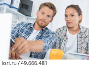 Male technician teaching female counterpart. Стоковое фото, агентство Ingram Publishing / Фотобанк Лори
