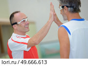 portrait of men giving high five. Стоковое фото, агентство Ingram Publishing / Фотобанк Лори