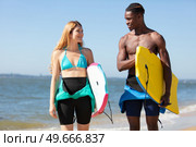couple of body boarders talking to eachother. Стоковое фото, агентство Ingram Publishing / Фотобанк Лори
