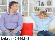 Father and son sitting separately not talking to eachother. Стоковое фото, агентство Ingram Publishing / Фотобанк Лори