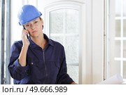 woman in overalls using telephone inside property. Стоковое фото, агентство Ingram Publishing / Фотобанк Лори