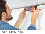 mason checking level of house wall. Стоковое фото, агентство Ingram Publishing / Фотобанк Лори
