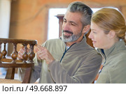 furniture maker in the workshop pointing at chair design. Стоковое фото, агентство Ingram Publishing / Фотобанк Лори