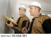 a young plasterer with manager. Стоковое фото, агентство Ingram Publishing / Фотобанк Лори