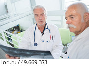 two doctors with xray on white. Стоковое фото, агентство Ingram Publishing / Фотобанк Лори