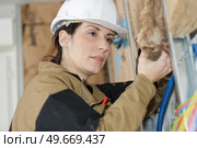 female worker placing styrofoam sheet insulation to foundation house. Стоковое фото, агентство Ingram Publishing / Фотобанк Лори