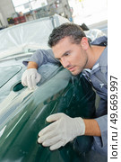 Mechanic assessing wing of classic car. Стоковое фото, агентство Ingram Publishing / Фотобанк Лори