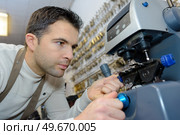 young professional with different types of keys in locksmith. Стоковое фото, агентство Ingram Publishing / Фотобанк Лори