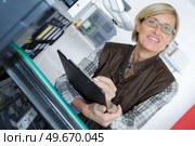 woman fixing a photocopier during maintenance using a screwdriver. Стоковое фото, агентство Ingram Publishing / Фотобанк Лори