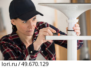 female worker assembling a metal chair. Стоковое фото, агентство Ingram Publishing / Фотобанк Лори