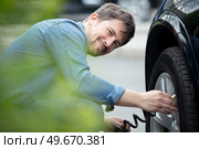 man inflating rear car tyre. Стоковое фото, агентство Ingram Publishing / Фотобанк Лори
