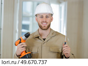 happy builder handyman working with electric drill indoors. Стоковое фото, агентство Ingram Publishing / Фотобанк Лори