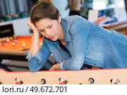 bored woman alone while husband is playing table football. Стоковое фото, агентство Ingram Publishing / Фотобанк Лори