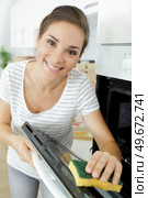 woman cleaning the oven in her kitchen. Стоковое фото, агентство Ingram Publishing / Фотобанк Лори