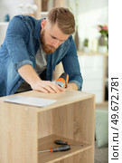 man assembles furniture in the home. Стоковое фото, агентство Ingram Publishing / Фотобанк Лори