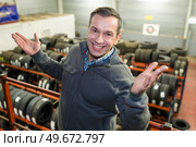 technician man promoting new tyres in car tire shop. Стоковое фото, агентство Ingram Publishing / Фотобанк Лори