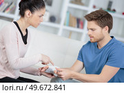 Woman questioning man about bangdaged hand. Стоковое фото, агентство Ingram Publishing / Фотобанк Лори