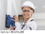 female construction worker smoothing wall surface. Стоковое фото, агентство Ingram Publishing / Фотобанк Лори