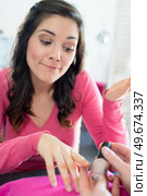 lady unsure about proposed nail polish colour. Стоковое фото, агентство Ingram Publishing / Фотобанк Лори