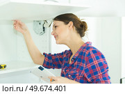 woman inspecting her installed cupboard. Стоковое фото, агентство Ingram Publishing / Фотобанк Лори