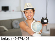 woman holding globe and piggy bank. Стоковое фото, агентство Ingram Publishing / Фотобанк Лори