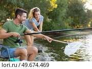 couple fishing at the river with fishing rod and net. Стоковое фото, агентство Ingram Publishing / Фотобанк Лори
