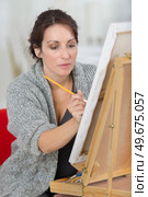 female painter drawing in art studio using easel. Стоковое фото, агентство Ingram Publishing / Фотобанк Лори