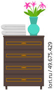 Wooden commode with drawers, bedside table. Furniture made of natural dark wood. Organization of home, nightstand. Flower in vase and towels on chest of drawers. Element of home interior design. Wooden commode, bedside table. Flower in vase and towels on chest of drawers, home furniture. Стоковая иллюстрация, агентство Ingram Publishing / Фотобанк Лори