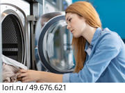 beautiful female employee working at laundromat shop. Стоковое фото, агентство Ingram Publishing / Фотобанк Лори
