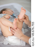 mother cleaning up her babys buttocks with wet hankies. Стоковое фото, агентство Ingram Publishing / Фотобанк Лори