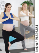 two pregnant woman doing yoga. Стоковое фото, агентство Ingram Publishing / Фотобанк Лори