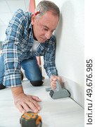 man installing light laminate flooring in a room. Стоковое фото, агентство Ingram Publishing / Фотобанк Лори
