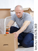a man taping the boxes. Стоковое фото, агентство Ingram Publishing / Фотобанк Лори