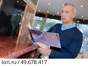senior man choosing marble in store. Стоковое фото, агентство Ingram Publishing / Фотобанк Лори