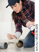 female plumber gluing pipe together. Стоковое фото, агентство Ingram Publishing / Фотобанк Лори