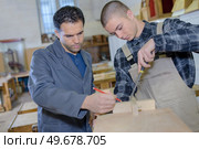 Young men in woodworking room. Стоковое фото, агентство Ingram Publishing / Фотобанк Лори