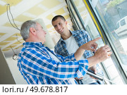 two builders worker installing glass windows. Стоковое фото, агентство Ingram Publishing / Фотобанк Лори
