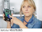 woman using stethoscope to pc component. Стоковое фото, агентство Ingram Publishing / Фотобанк Лори