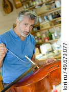 portrait of a man repairing cello. Стоковое фото, агентство Ingram Publishing / Фотобанк Лори