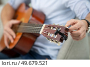 male hands tune acoustic guitar. Стоковое фото, агентство Ingram Publishing / Фотобанк Лори