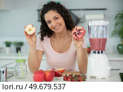 woman showing cut fruit for juicing. Стоковое фото, агентство Ingram Publishing / Фотобанк Лори