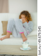School girl on couch, glass of milk on table. Стоковое фото, агентство Ingram Publishing / Фотобанк Лори