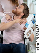 man reading a book on wheelchair with his wife. Стоковое фото, агентство Ingram Publishing / Фотобанк Лори