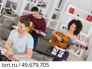 three musicians playing together two guitarists and one on keyboard. Стоковое фото, агентство Ingram Publishing / Фотобанк Лори