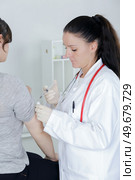 pediatrician giving an injection in arm. Стоковое фото, агентство Ingram Publishing / Фотобанк Лори