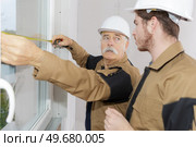 two workers measuring windows. Стоковое фото, агентство Ingram Publishing / Фотобанк Лори